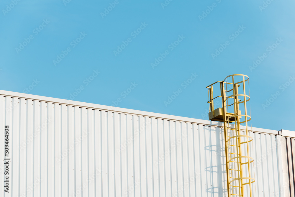 une échelle jaune montant sur un toit de bâtiment une échelle jaune montant sur un toit de bâtiment