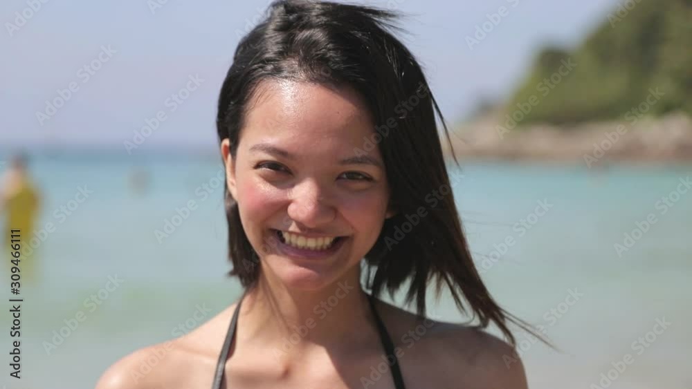 close up young woman in black bikini smiling portrait on the beach in background, smile friendly and show her hands to invite to the beach close up young woman in black bikini smiling portrait on the beach in background, smile friendly and show her hands to invite to the beach