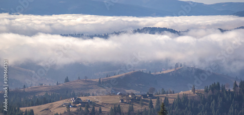 Village in the mountains in the foggy autumn day