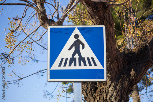 Pedestrian sign in blue with a tree