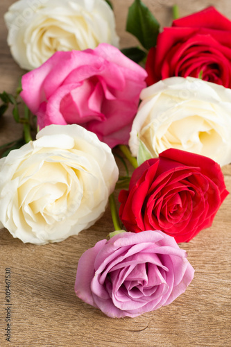Group of white  red and pink roses over a wooden table
