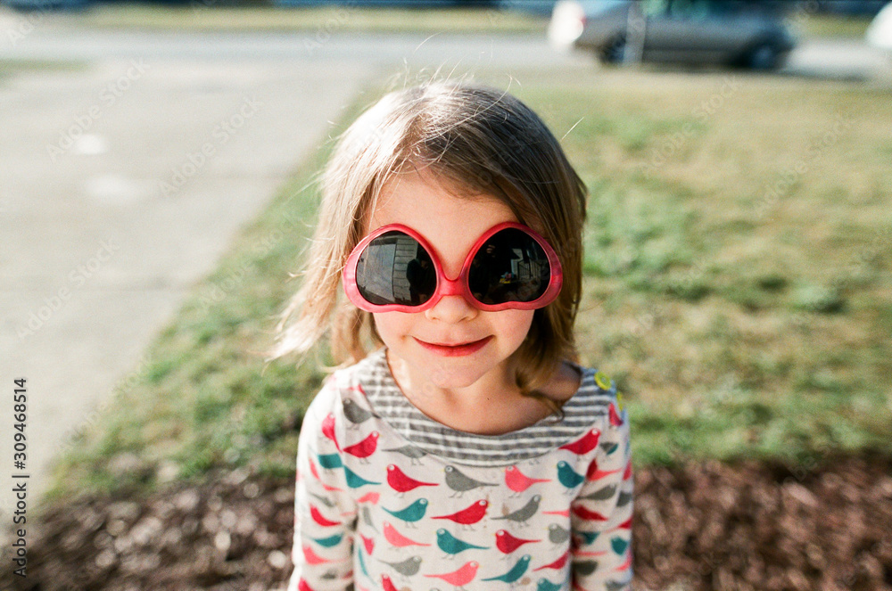 portrait of smiling girl with upside down heart sunglasses portrait of smiling girl with upside down heart sunglasses
