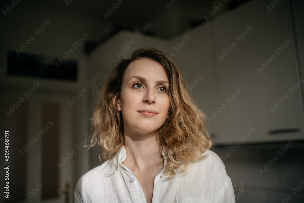 Happy dreamy woman standing in kitchen in morning Happy dreamy woman standing in kitchen in morning