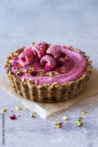 Raw berry vegan tart with nut crust photo