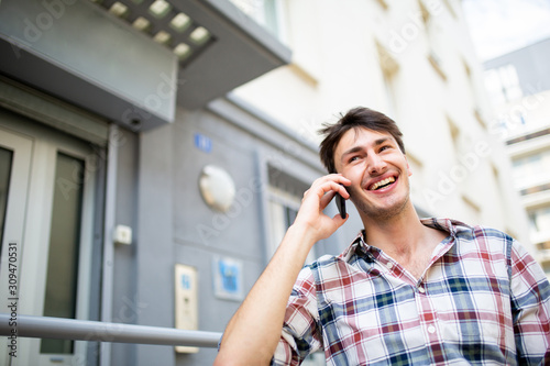 happy young man talking with cellphone outside