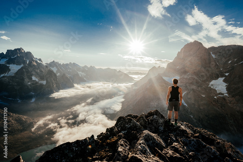 Man on rocky cliff above amazing valley