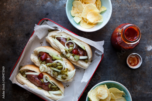 Sausages in bread buns with relish and potato chips