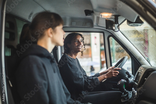 Mover looking in rear view mirror while driving delivery van photo