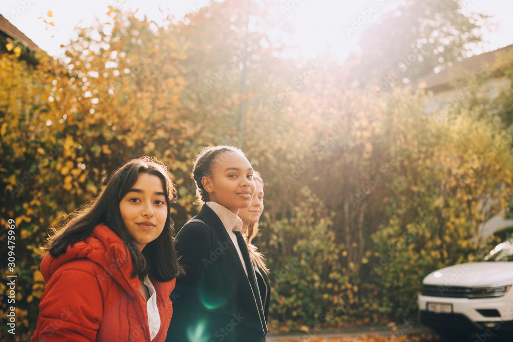Portrait of smiling teenage girls in city during autumn Portrait of smiling teenage girls in city during autumn