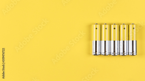 Konstfotografi Photo of five gray-yellow alkaline AA batteries on a yellow background