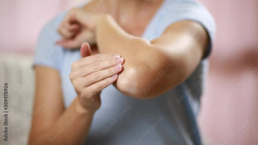 Woman applies cream on her elbow isolated. People, healthcare and medicine concept Woman applies cream on her elbow isolated. People, healthcare and medicine concept