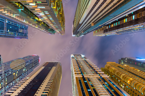 Below view on the luxury modern skyscrapers in Dubai Marina, shot at cloudy night. UAE lifestyle. 