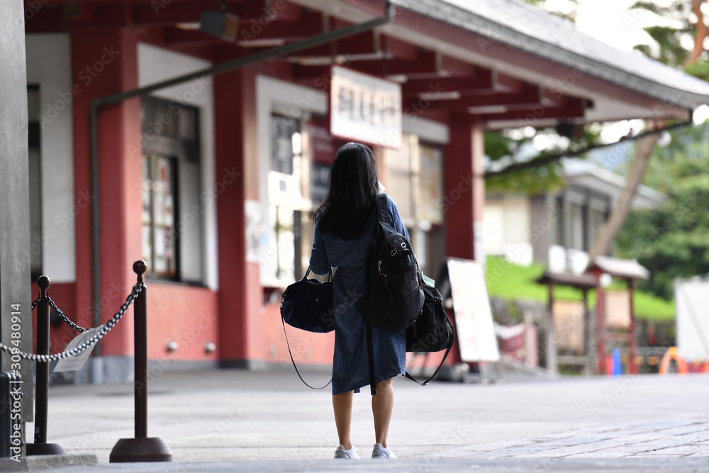 A young Japanese woman is waiting at the entrance of a museum for the opening.