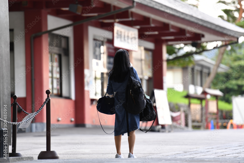 Φωτογραφία A young Japanese woman is waiting at the entrance of a museum for the opening