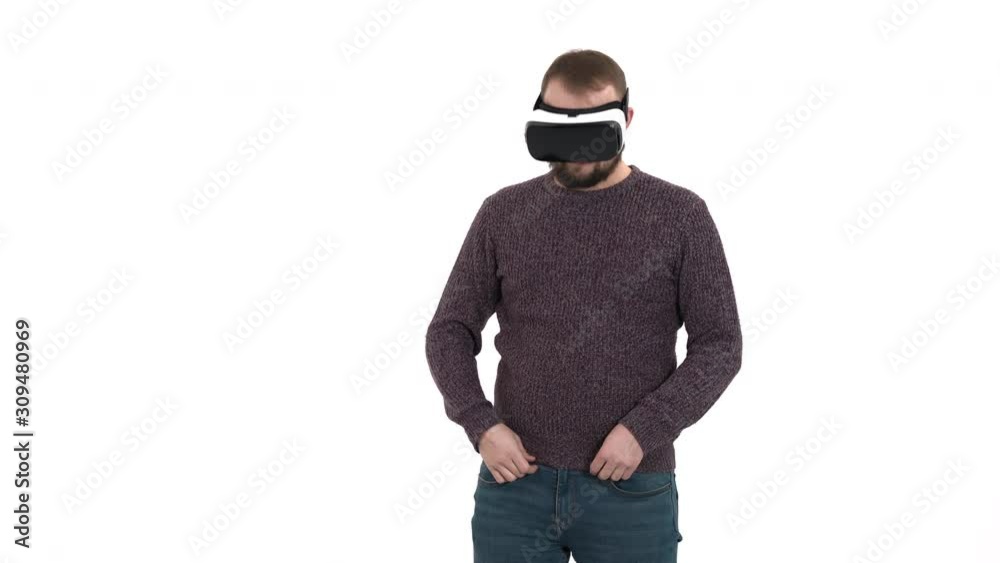Young hipster man using virtual reality technology gadget. Man surprised by augmented reality in VR glasses, on a white background Young hipster man using virtual reality technology gadget. Man surprised by augmented reality in VR glasses, on a white background