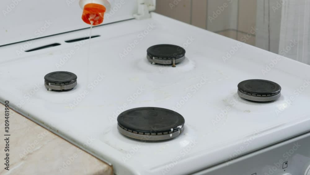 the process of applying the cleaning agent to the surface of the stove and cleaning it with a yellow sponge the process of applying the cleaning agent to the surface of the stove and cleaning it with a yellow sponge