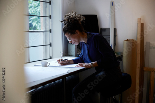 Side view of confident female architect working in office photo