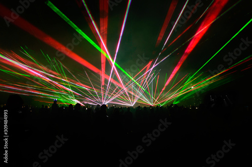 Obraz na płótnie People bathed in fog and laser light, laser show. w salonie