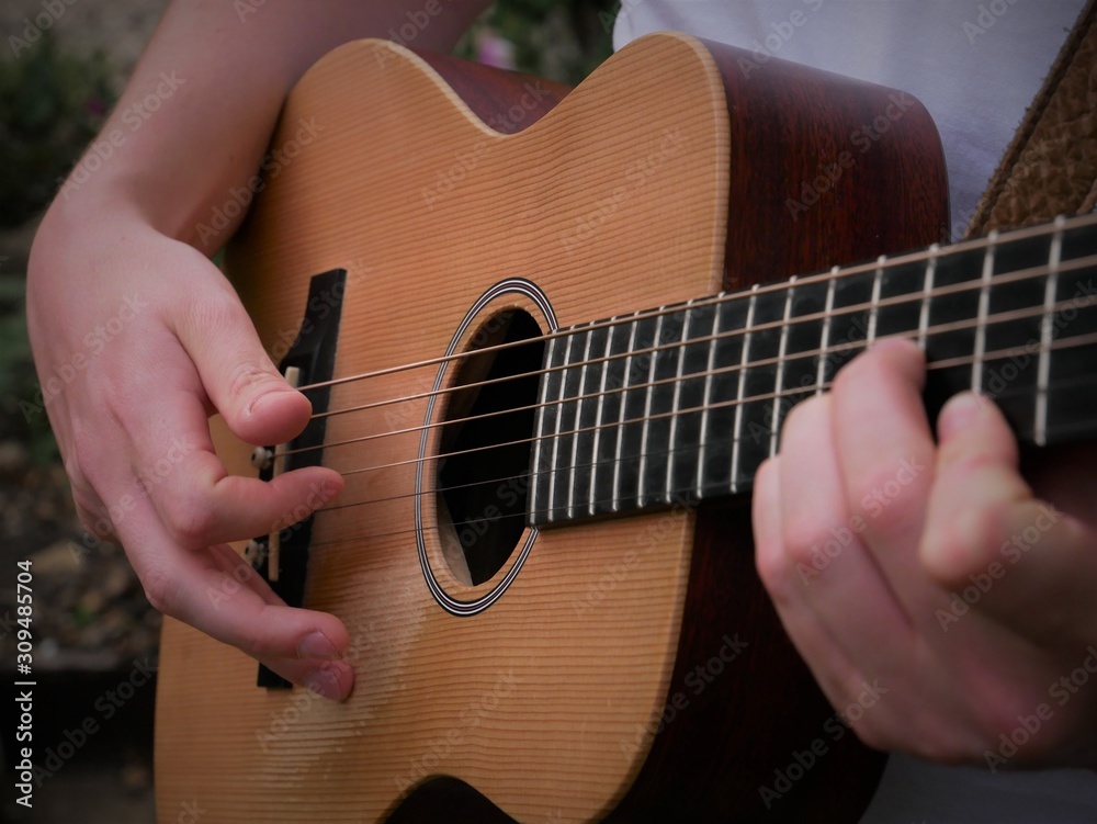 Fototapeta Acoustic guitar playing musician close up of guitar, strings, fretboard and hands