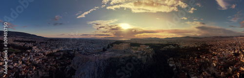 Aerial drone panoramic photo of beautiful sunset with golden colours and clouds over iconic Acropolis hill and Masterpice of Western ancient civilisation - the Parthenon, Athens, Attica, Greece