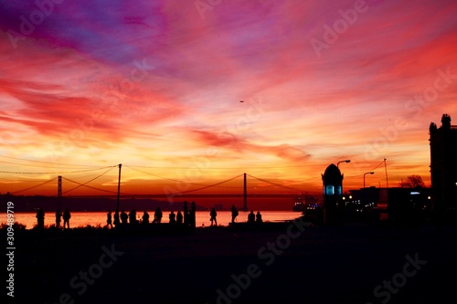 sunset in Lisbon city center with the 25 de Abril bridge on the background, Portugal 