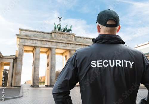 Senior Security Officer Standing In Front Of Brandenburg Gate