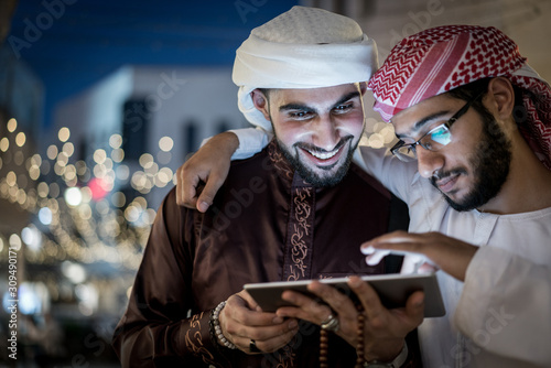 Valokuva Two Arab men with tablet in city at night