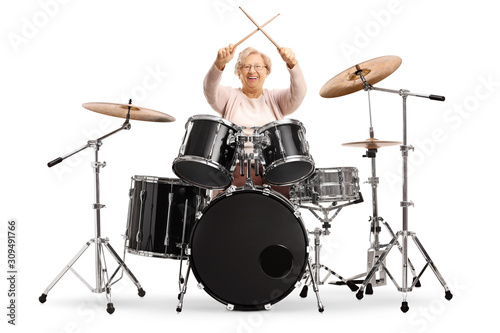 Senior woman holding crossed drumsticks with a set of drums Fototapeta