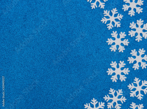 Christmas or winter blue background with white snowflakes. New Year greeting card. Christmas, New Year or winter concept. Flat lay style with copy space.
