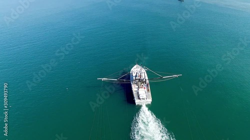 A White Trawling Shrimp Boat on the Water, Aerial Circling Point of Interest Shot photo