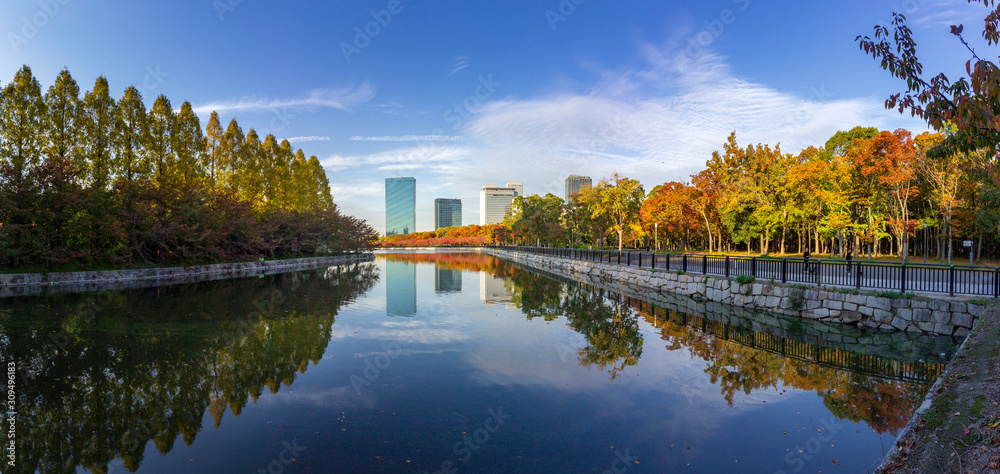Cloudscape and skyline urban cityscape reflection at Osaka Castle Park, Japan.