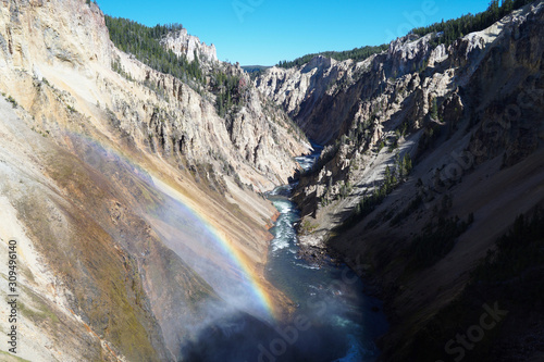The mist coming up from the force of Yellowstone's Lower Falls creates a rainbow in front of the river as it journeys down the canyon.