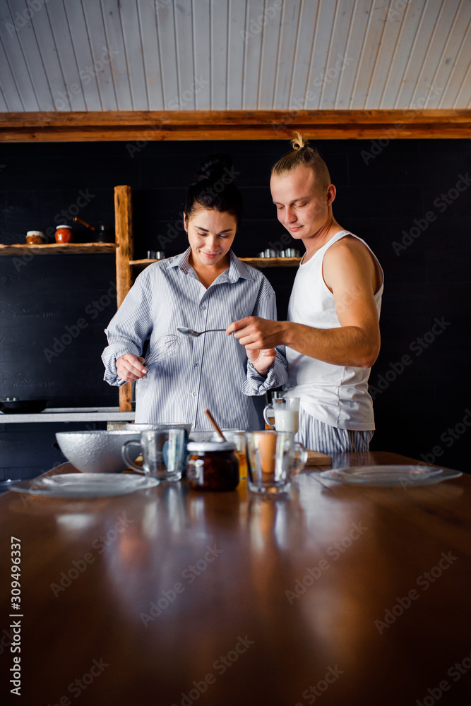 Couple preparing breakfast at home. The girl and the guy live together. Couple preparing breakfast at home. The girl and the guy live together.