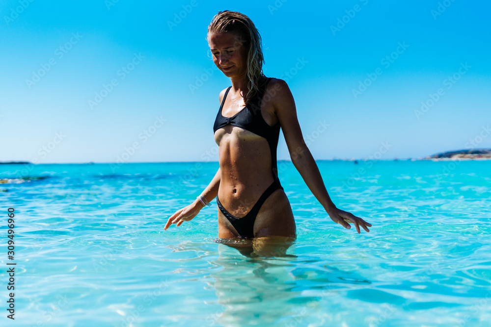 Young sexy fit blonde woman posing in ocean in micro one piece swimsuit  exposing boobs Stock Photo | Adobe Stock