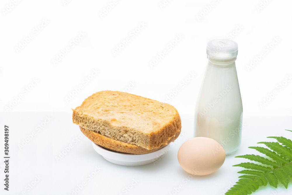 A nutritious breakfast of bread and eggs with milk, garnished with a green leaf. A nutritious breakfast of bread and eggs with milk, garnished with a green leaf.