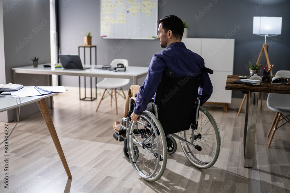 Businessman Sitting On Wheelchair In Office