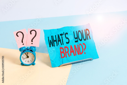 Conceptual hand writing showing What S Your Brand Question. Concept meaning asking about product logo does or what you communicate Alarm clock beside a Paper sheet placed on pastel backdrop