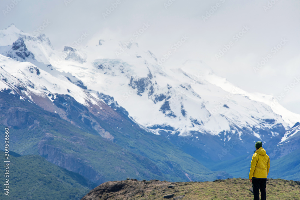A hiker man looks over the mountains in El Chalten, Patagonia, Argentina A hiker man looks over the mountains in El Chalten, Patagonia, Argentina