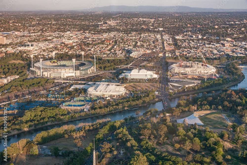 Melbourne, Australia - November 17, 2009: Aerial view on several sports venues and facilities of Olympic park along Yarra River and set in wider area showing suburbs and mountains on horizon.