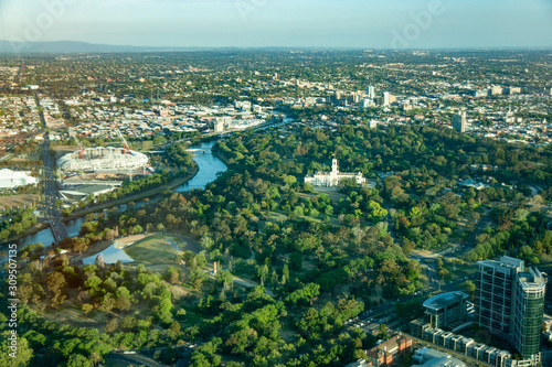 Melbourne, Australia - November 17, 2009: Aerial view on white Government House with tower and flag with surrounding botanical gardens. Wide veiw over eastern suburbs and Yarra river.