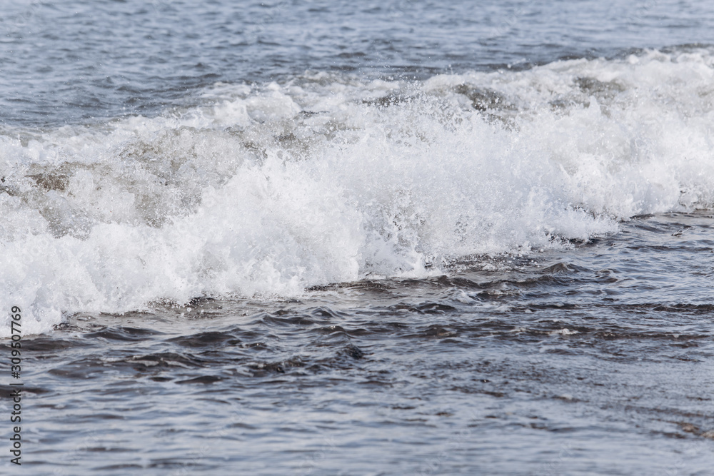 Waves on the beach. A surge of water ashore.