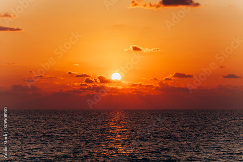 Beautiful sunset over the sea. Reflection of sunset in the sea. Orange sunset.