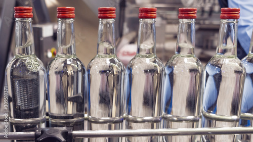 The bottles on the conveyor belt at the plant for bottling of alcoholic beverages, Russian vodka