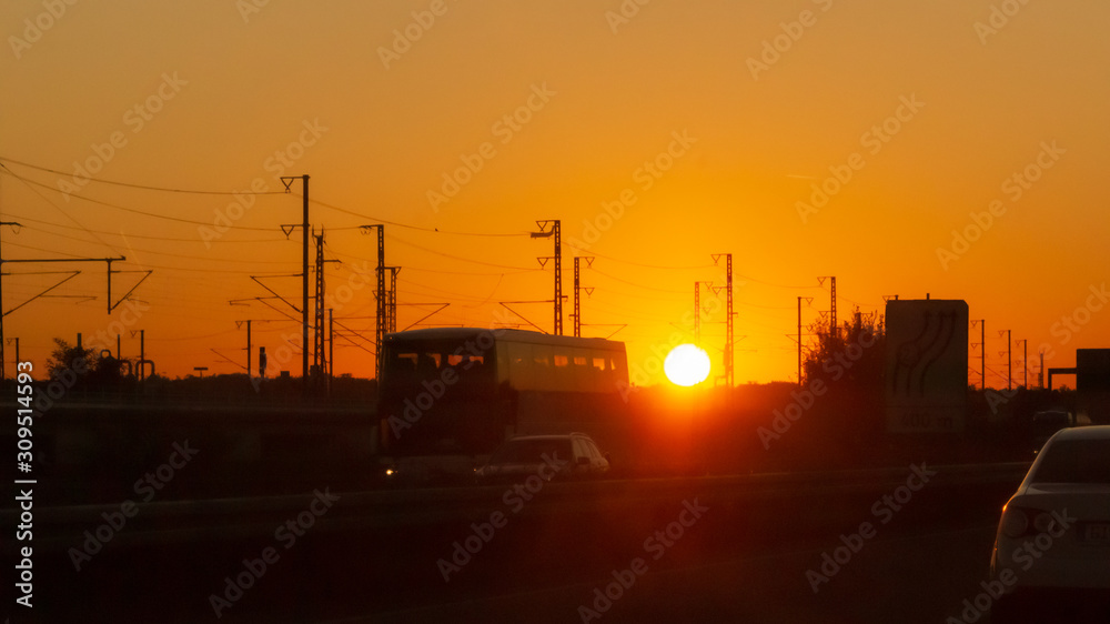 Reisebus Silhouette vor aufgehender Sonne im Morgenrot