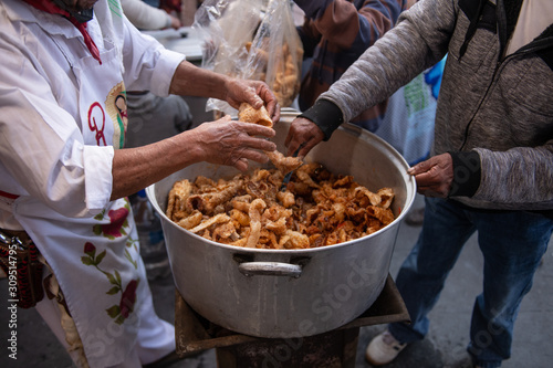 man cooking a typical Mexican meal known as "chicharron en rajas" in a typical comal