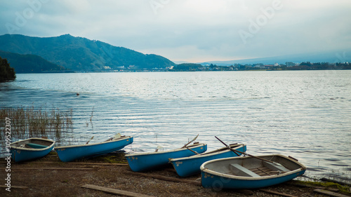 Many boats on ground at side of lake, vintage color style
