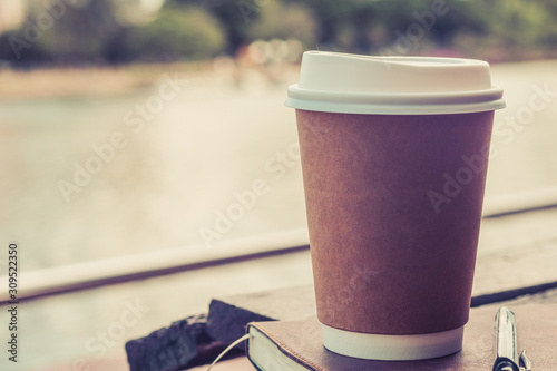 Brown paper cup of coffee photos in the park with copy space. Concept of beverage of enjoy drink and relax with happy time to get rest and leisure. Object photo mock up for branding and logo.