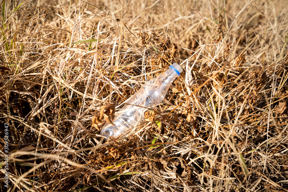 A plastic bottle junk is leaved on ground floor, it is major environment pollution after long vacation. Garbage from tourist.