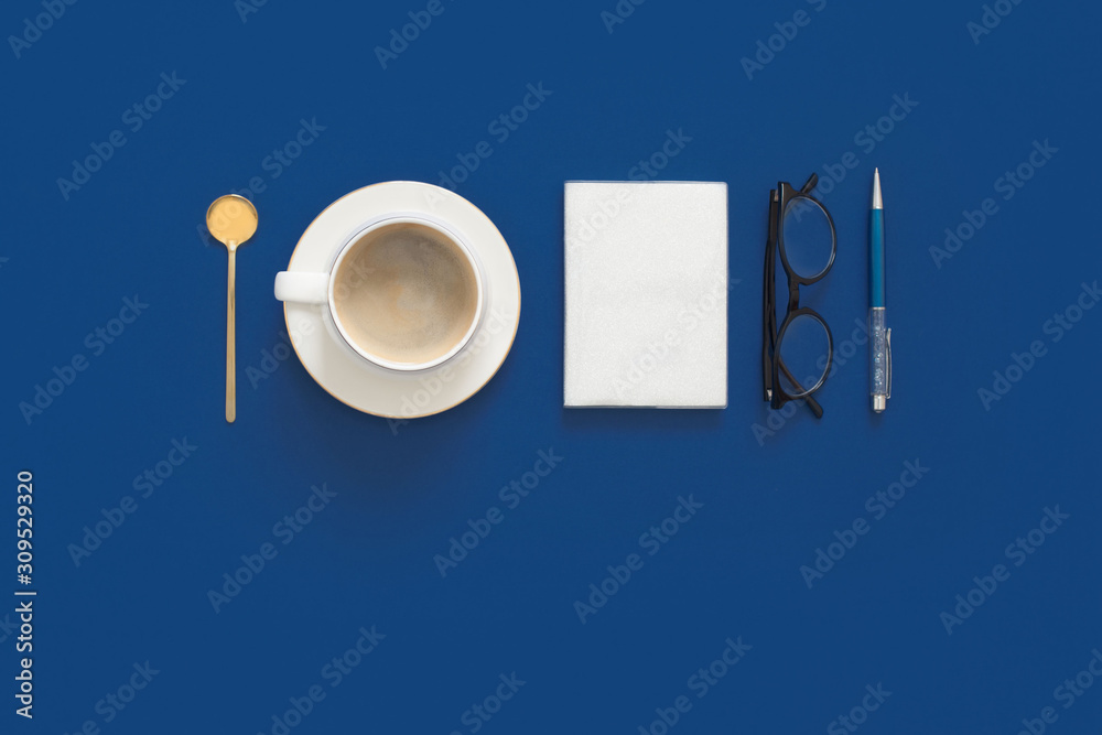 Classic Blue. Color of the Year 2020. Top view of workspace with laptop, succulent, glasses, coffee and copy space on colored blue background. Flatlay minimalism