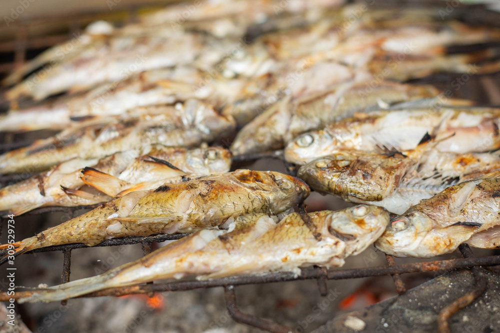 Grill fish on a stove that uses charcoal as fuel for grilling Grill fish on a stove that uses charcoal as fuel for grilling